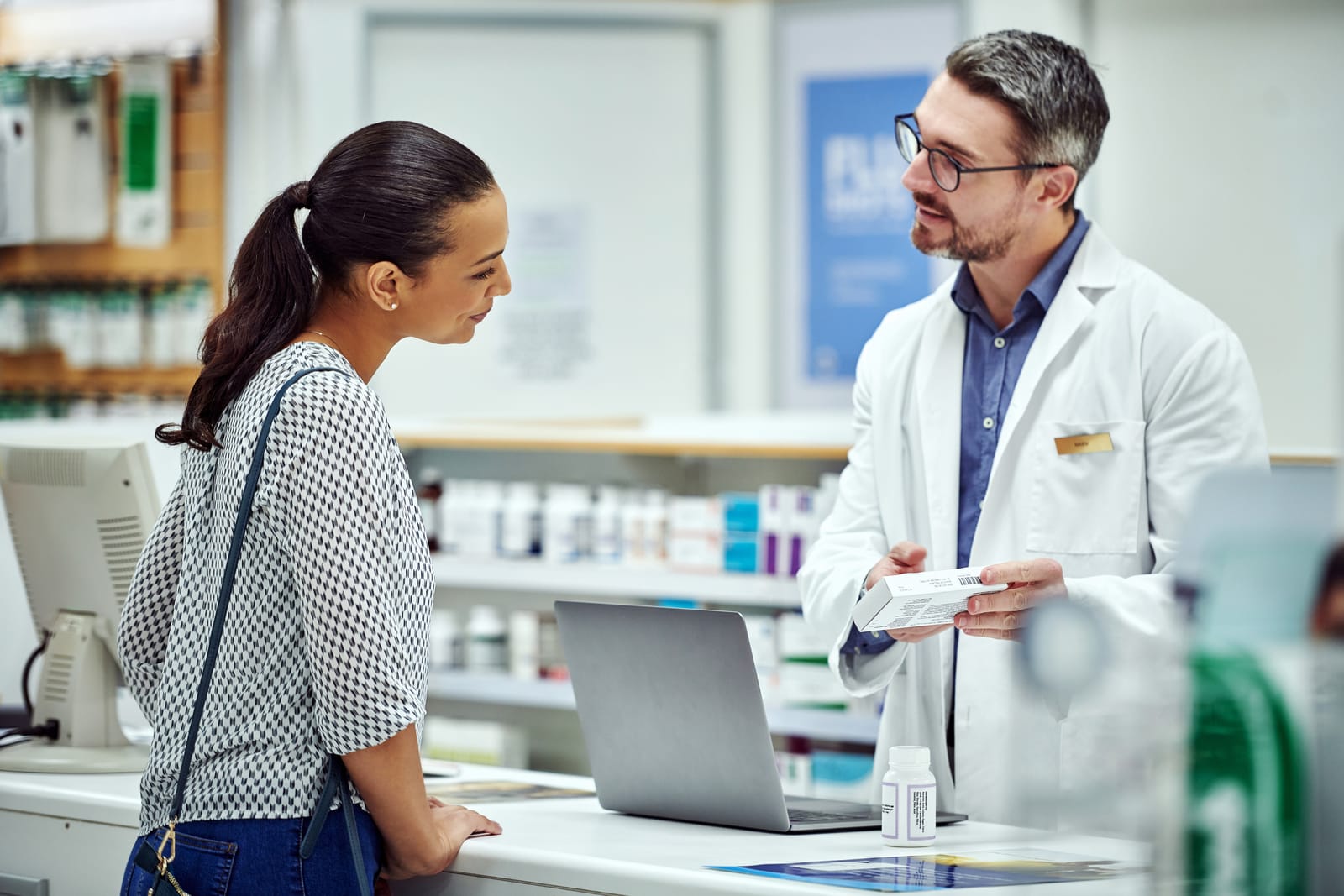 Farmacéutico asesora a una clienta sobre un suplemento