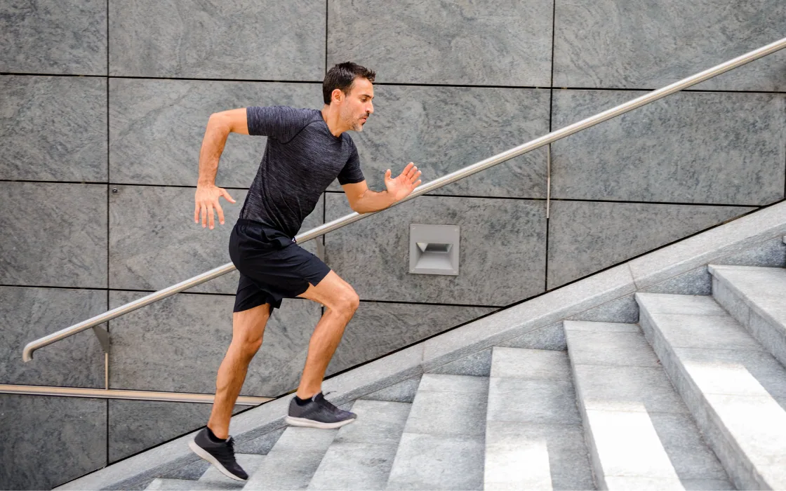 Hombre corre subiendo unas escaleras de hormigón
