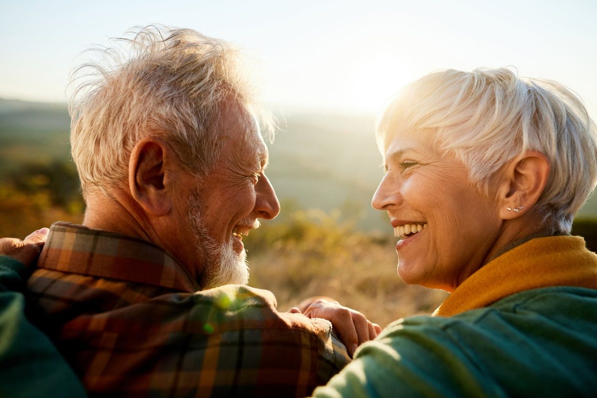 Pareja mayor riéndose a la luz del atardecer